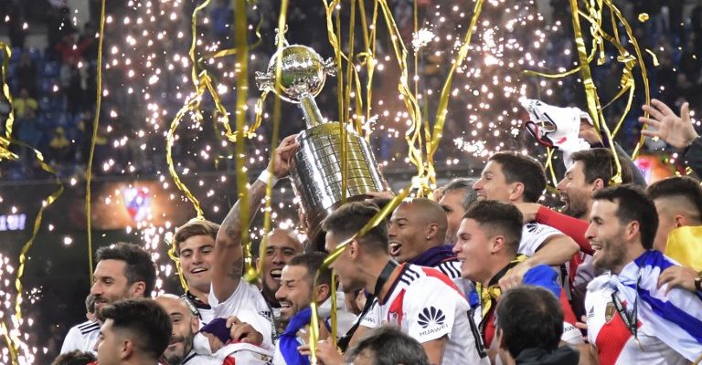 Players of River Plate celebrate with the trophy after winning the second leg match of the all-Argentine Copa Libertadores final against Boca Juniors, at the Santiago Bernabeu stadium in Madrid, on December 9, 2018. (Photo by Javier SORIANO / AFP)
