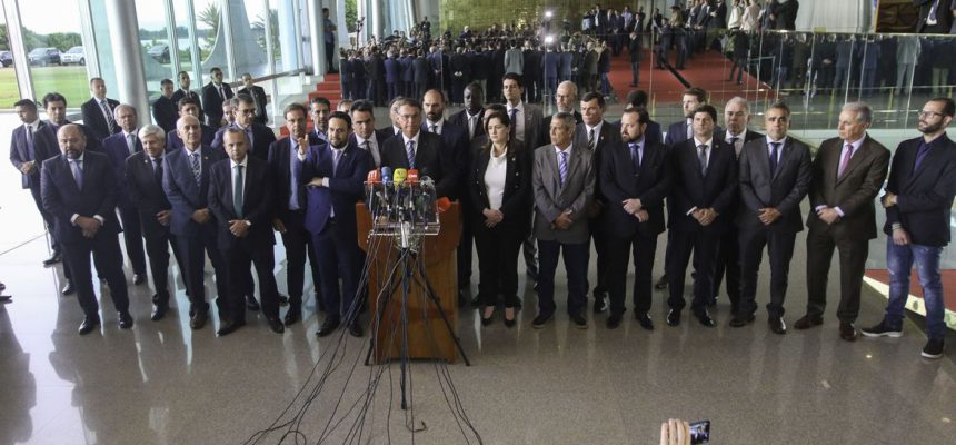 Presidente Jair Bolsonaro, acompanhado de vários ministros, fala com a imprensa no Palácio da Alvorada