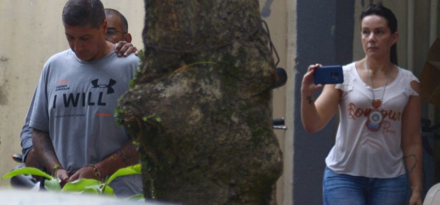 Ronnie Lessa, suspeito do assassinato da vereadora Marielle Franco, é escoltada por um policial quando ele deixa o departamento de homicídios para prestar depoimento na justiça Rio de Janeiro.